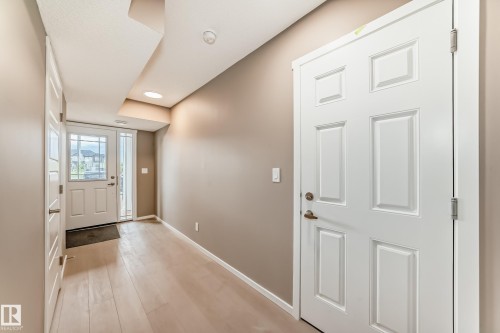 Foyer featuring light wood-finish flooring, recessed lighting, and a white paneled entry door with sidelights - 1210 Stoneside Road, Sherwood Park, AB - Indoor Photo Showing Other Room