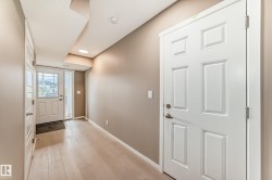 Foyer featuring light wood-finish flooring, recessed lighting, and a white paneled entry door with sidelights - 
