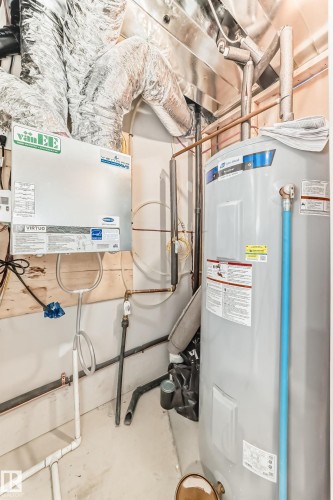 Utility area featuring a water heater, ventilation ducts, and various piping - 1210 Stoneside Road, Sherwood Park, AB - Indoor Photo Showing Basement