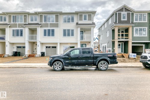 New construction townhome featuring a two-tone facade, attached garage, and a balcony with white railings - 1210 Stoneside Road, Sherwood Park, AB - Outdoor With Balcony With Facade