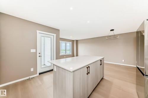 Kitchen island featuring a light-toned wood-finish base with dark hardware and a white countertop - 1210 Stoneside Road, Sherwood Park, AB - Indoor