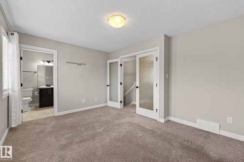 Carpeted room with light neutral wall paint and white trim - 64 South Creek Wynd, Stony Plain, AB 