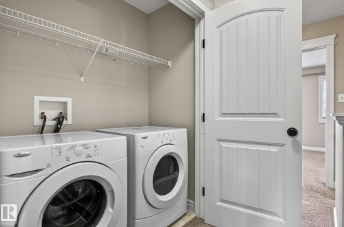 Dedicated laundry area featuring a wire storage shelf, utility hookups, and neutral wall paint - 64 South Creek Wynd, Stony Plain, AB 