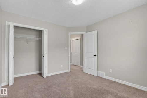 Carpeted room with light grey walls and white trim - 64 South Creek Wynd, Stony Plain, AB 