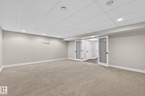 Spacious room with light-toned carpet, neutral wall color, and white trim - 64 South Creek Wynd, Stony Plain, AB 