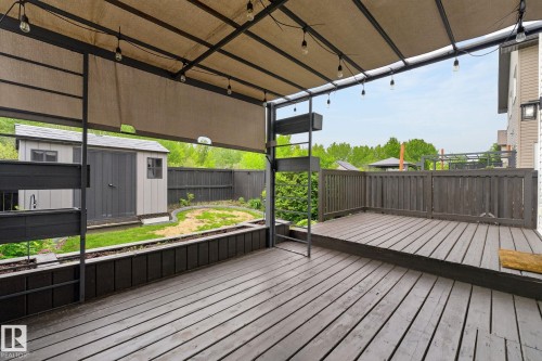 Spacious outdoor deck with a shade canopy and string lighting - 64 South Creek Wynd, Stony Plain, AB 