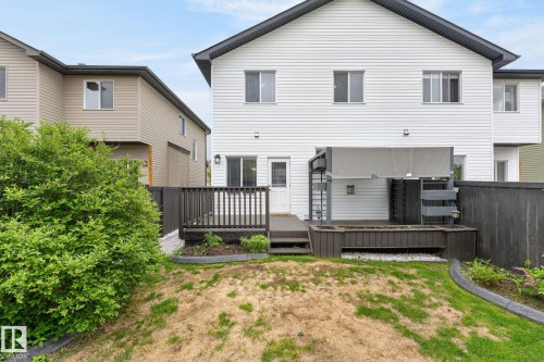 Rear exterior featuring white horizontal siding and a dark shingled roof - 64 South Creek Wynd, Stony Plain, AB 