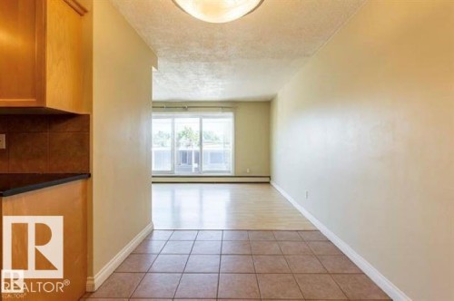 Tiled entry flooring extending to wood-finish flooring - 307 8215 83 Avenue, Edmonton, AB 