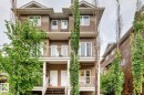 Two-unit multi-story property featuring a stucco exterior, multiple balconies with white railings, and individual front entrances with white doors - 4 11917 103 Street, Edmonton, AB 
