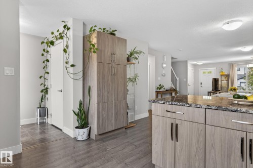 Kitchen island featuring a granite-style countertop and light wood-finish cabinetry with silver-tone hardware - 33 Durrand Bend, Fort Saskatchewan, AB 