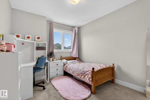 Carpeted room featuring light gray walls, a ceiling-mounted light fixture, and a window with white trim - 33 Durrand Bend, Fort Saskatchewan, AB 