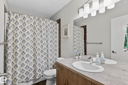 Bathroom vanity featuring an oval undermount sink, a chrome single-handle faucet, and a large mirror - 33 Durrand Bend, Fort Saskatchewan, AB 