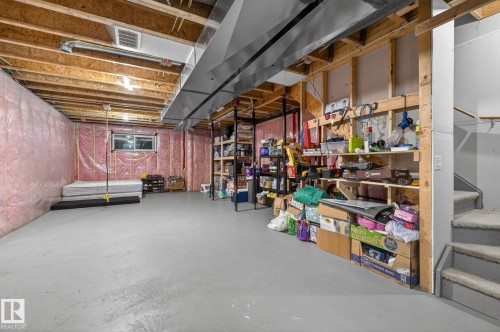 Unfinished basement featuring exposed wood joists and structural beams, along with a painted concrete floor - 33 Durrand Bend, Fort Saskatchewan, AB 