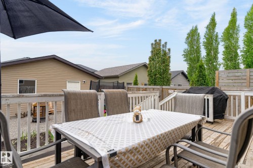 Expansive outdoor deck featuring wood flooring, white painted railings, and steps to a lower level - 33 Durrand Bend, Fort Saskatchewan, AB 