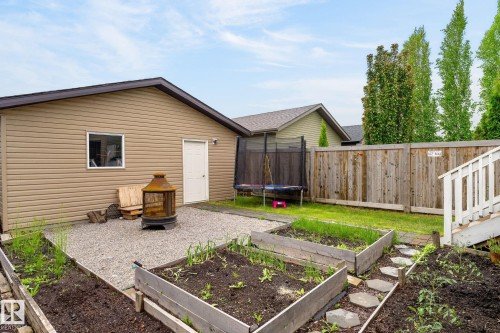Detached garage with tan siding, a white service door, and a single window - 33 Durrand Bend, Fort Saskatchewan, AB 