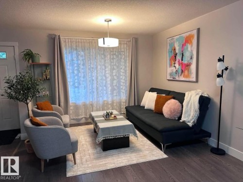 Living area featuring dark wood-finish flooring and light wall colors - 33 Durrand Bend, Fort Saskatchewan, AB 