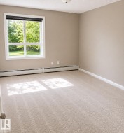 Spacious room with plush light-colored carpeting, neutral painted walls, and white trim - 