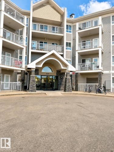 Multi-level residential building featuring a stone-clad entrance with an arched portico - 115 5340 199 Street, Edmonton, AB - Outdoor