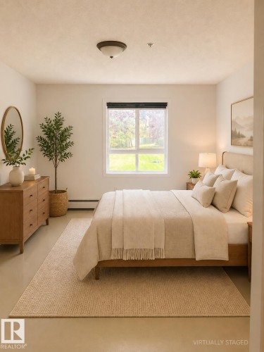 Bright bedroom featuring a large window, neutral wall tones, and overhead lighting - 115 5340 199 Street, Edmonton, AB - Indoor Photo Showing Bedroom