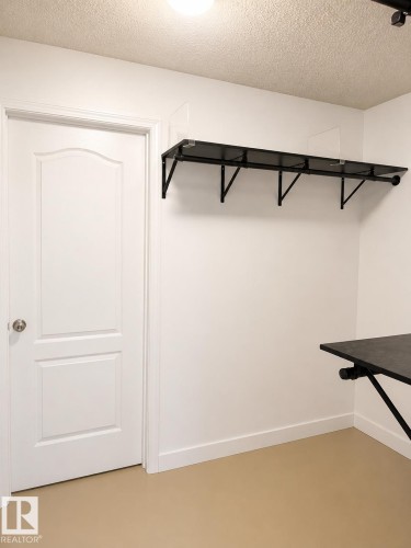 White paneled door with round knob, white baseboards, and light-colored flooring - 115 5340 199 Street, Edmonton, AB - Indoor