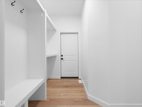 Built-in storage solutions featuring a bench, shelving, and coat hooks - 214 Crystal Creek Drive, Leduc, AB 