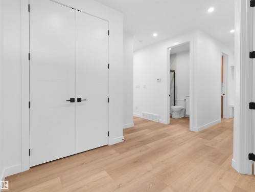 Hallway featuring light wood-finish flooring, white walls, and recessed lighting - 214 Crystal Creek Drive, Leduc, AB 