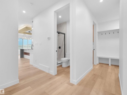 Hallway with light wood-finish flooring, recessed lighting, and white baseboards - 214 Crystal Creek Drive, Leduc, AB 