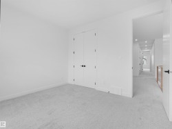 Carpeted room featuring white walls, white trim, and a double-door closet with black hardware - 