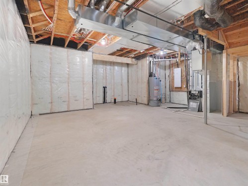 Unfinished basement with concrete flooring, insulated walls, exposed wood ceiling joists, and visible HVAC ductwork - 214 Crystal Creek Drive, Leduc, AB 