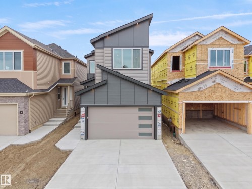 Modern architectural design featuring a multi-tone gray exterior and a distinctive angular roofline - 214 Crystal Creek Drive, Leduc, AB 