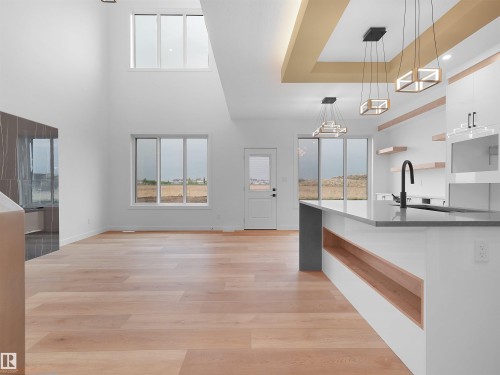 Expansive interior featuring high ceilings, light wood-finish flooring, and multiple windows - 214 Crystal Creek Drive, Leduc, AB 