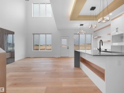 Expansive interior featuring high ceilings, light wood-finish flooring, and multiple windows - 