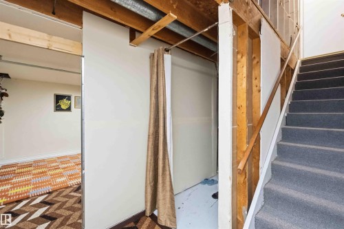Carpeted stairs with natural wood handrail - 203 11421 34 Street Nw, Edmonton, AB 