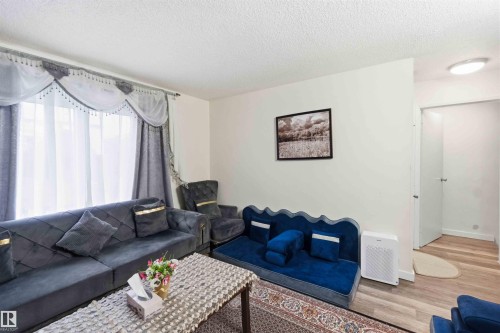 Bright living space featuring light-toned walls and wood-finish flooring - 203 11421 34 Street Nw, Edmonton, AB 