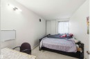 Bedroom featuring light-colored carpeting, white walls, and a window with sheer curtains - 203 11421 34 Street Nw, Edmonton, AB 
