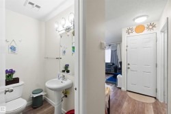 Powder room featuring a pedestal sink, toilet, and wood-finish flooring - 