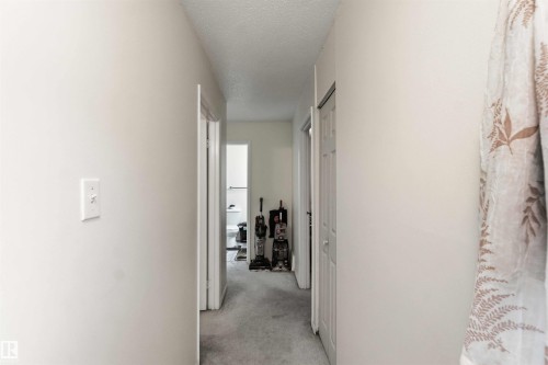 Interior hallway featuring light-colored walls and grey carpeting - 203 11421 34 Street Nw, Edmonton, AB 