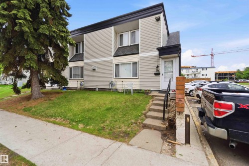Two-story residential building with light-colored horizontal siding and dark trim - 203 11421 34 Street Nw, Edmonton, AB 