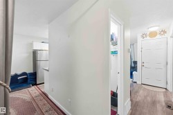Entryway with wood-finish flooring, white paneled door, and overhead lighting - 