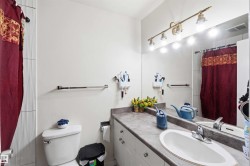 Full-width vanity mirror with a four-light brass fixture, white oval undermount sink, and a gray countertop - 