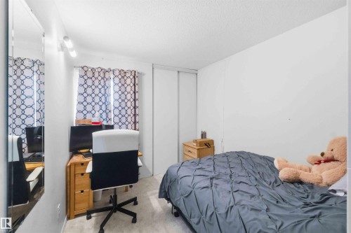 Spacious room featuring light-colored walls and soft carpeting - 203 11421 34 Street Nw, Edmonton, AB 