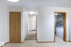 Hallway with tile flooring, wood-finish bi-fold door, and overhead lighting - 