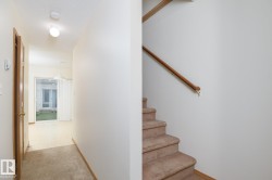 Carpeted staircase with wooden handrail - 