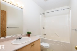 Bathroom featuring a vanity with an oval sink, laminate countertop, and light wood cabinetry - 