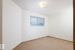 Carpeted room with white walls, a single window, and a flush-mount ceiling light fixture - 
