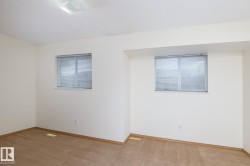 Room featuring two windows with horizontal blinds, neutral carpet, and white walls - 