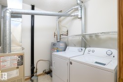 Dedicated utility area featuring a furnace unit, water heater, and laundry appliances - 