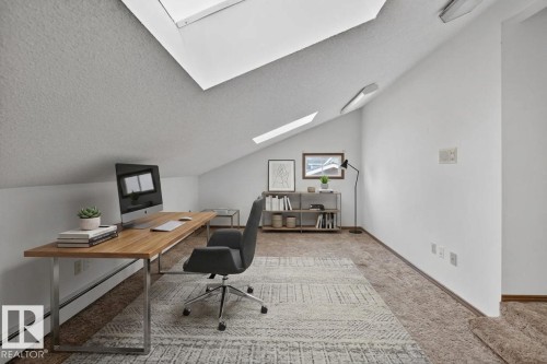 Slanted ceilings with multiple skylights, neutral wall tones, and carpeted flooring - 14808 55 Street, Edmonton, AB 
