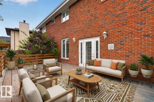Expansive outdoor patio featuring durable brick siding, a wood deck section, and a stone paver section - 14808 55 Street, Edmonton, AB 