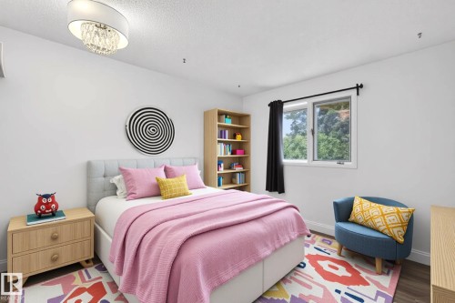 Bedroom featuring a tufted headboard, wood-finish flooring, and a window with exterior tree scenery - 14808 55 Street, Edmonton, AB 